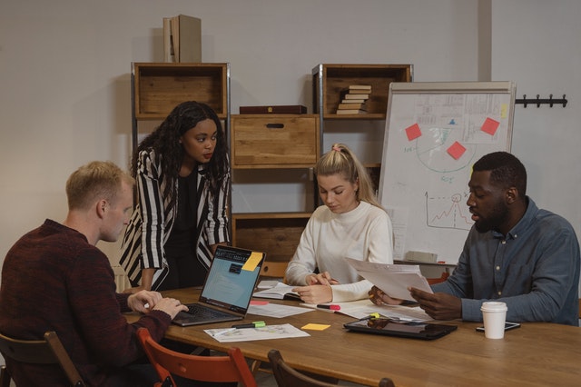 Woman in black and white striped long sleeve shirt sitting beside woman in white long sleeve